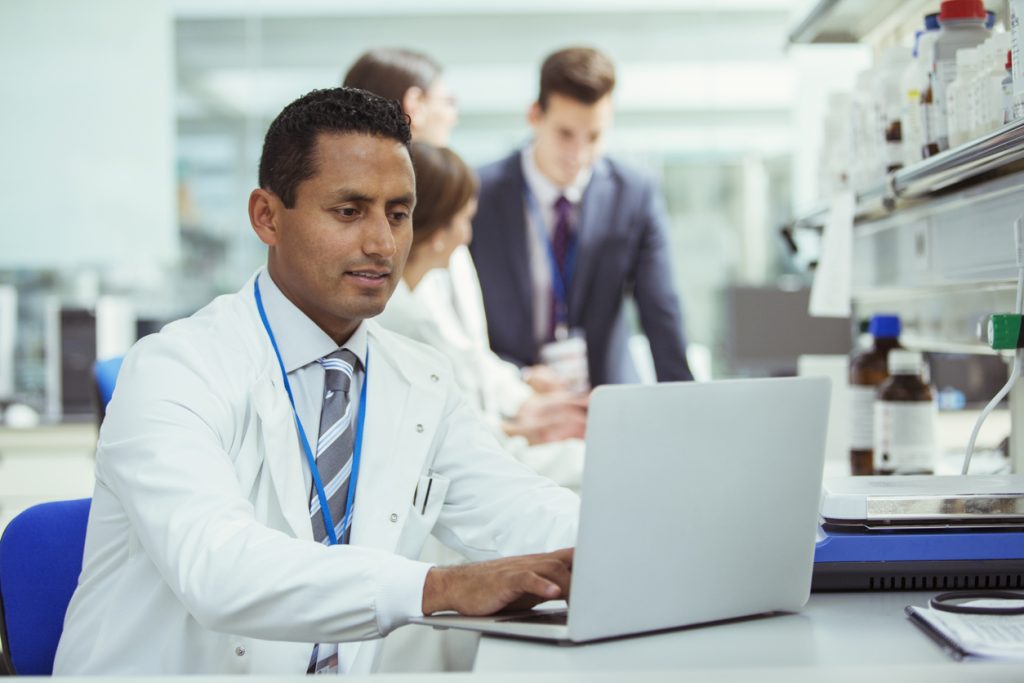 Scientist using laptop in laboratory